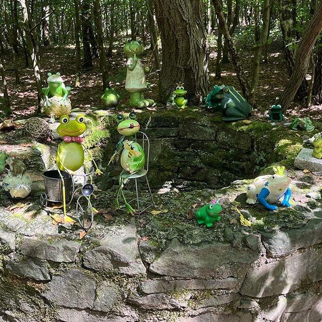 Brunnen mit Deko-Fröschen im Sommer auf Etappe 7 des neanderlandSTEIGs im Wald bei Landsberg