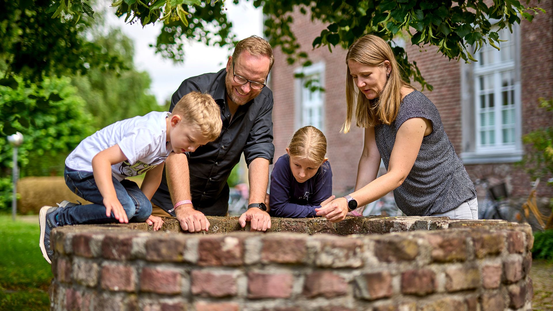 Familie erforscht im Sommer einen Brunnen im Kloster Saarn in Mülheim an der Ruhr