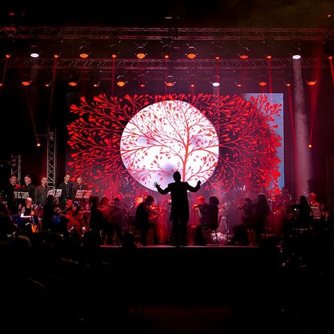 Orchester „Lord of the Sound” auf der Bühne mit roten Lichteffekten im HIntergrund