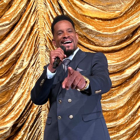 Sänger singt ins Mikrofon, im Hintergrund ein goldener Vorhand